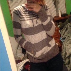 Knitted long sleeve with hood and pocket.